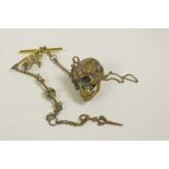 A novelty brass Albert chain with skull and bone details and links, 12½" long