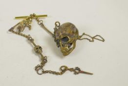 A novelty brass Albert chain with skull and bone details and links, 12½" long