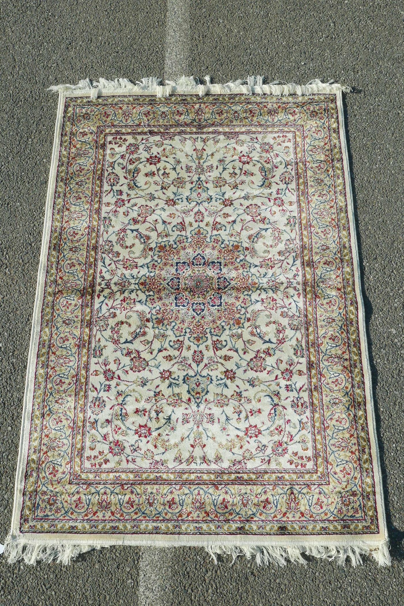 A cream ground Kashmir rug decorated with a Shabaz medallion design, 47" x 67"