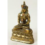 A Sino-Tibetan gilt brass figure of Buddha seated in meditation on a lotus throne, decorated with