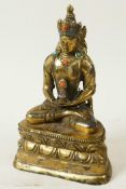 A Sino-Tibetan gilt brass figure of Buddha seated in meditation on a lotus throne, decorated with