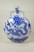 A Chinese blue and white porcelain two handled moon flask decorated with a dragon and the flaming