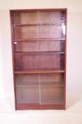 A Gibbs, mid C20th mahogany bookcase with sliding glass doors, 36" x 11" x 69"