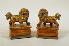 A pair of Chinese treacle glazed porcelain temple lion seals, 4" high