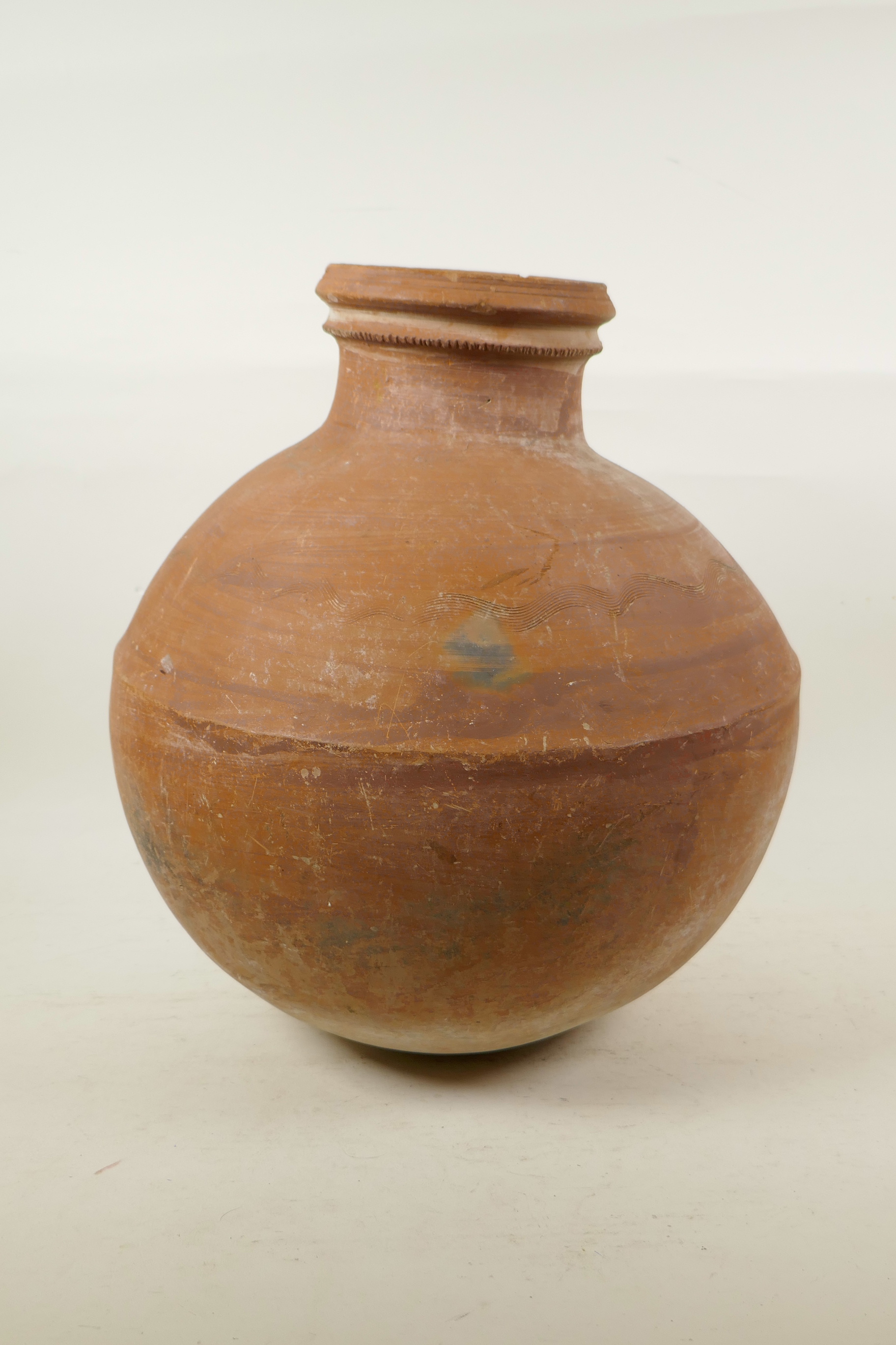 An Indian terracotta water vessel of globular form, 14" high, A/F chip to rim