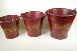 A set of three graduated metal buckets painted in red and with the Coca-Cola emblem, largest 14"