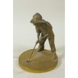 A small brass sundial cast as a young boy playing golf, 5¼" high