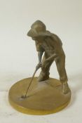 A small brass sundial cast as a young boy playing golf, 5¼" high