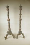 A pair of painted and distressed, turned wood, floor standing pricket candlesticks, A/F, 30½" high