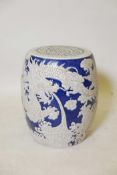 An Asian blue and white pottery garden seat decorated with a dragon and phoenix in flight, 16½" high