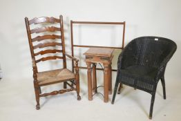 An oak ladderback armchair with a rush seat, a mahogany free standing towel rail, a Lloyd loom style