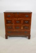 A walnut secretaire of small proportions, the fitted fall front secretaire over six small drawers