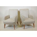 A pair of contemporary armchairs raised on splay supports, 35" high