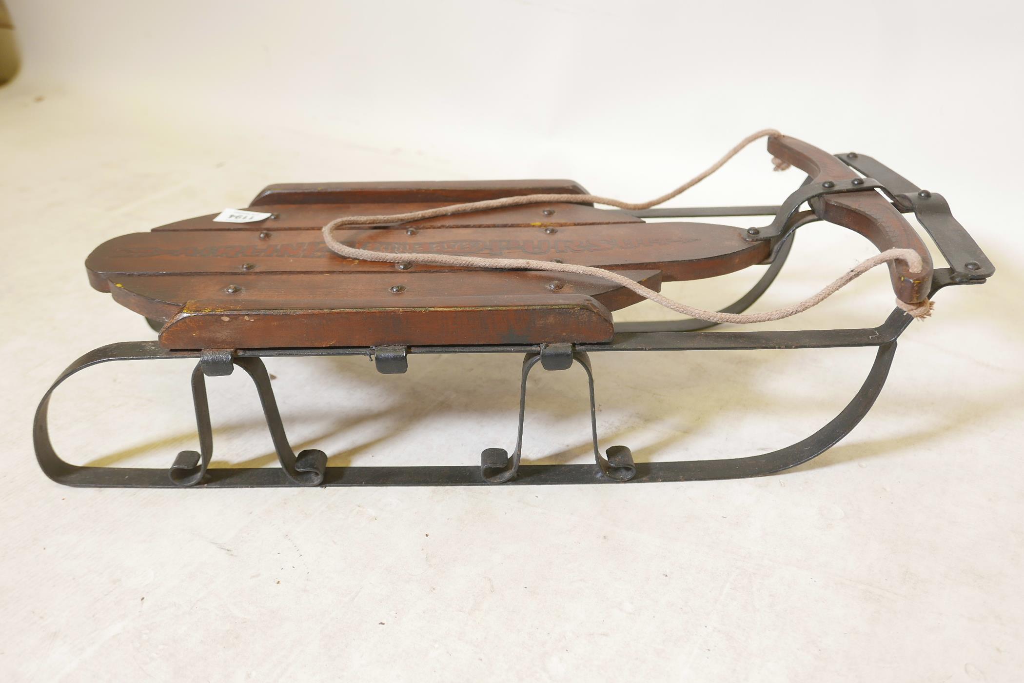 A wrought metal and wood 'Airline Pursuit' child's sled, 24" x 9" x 6"