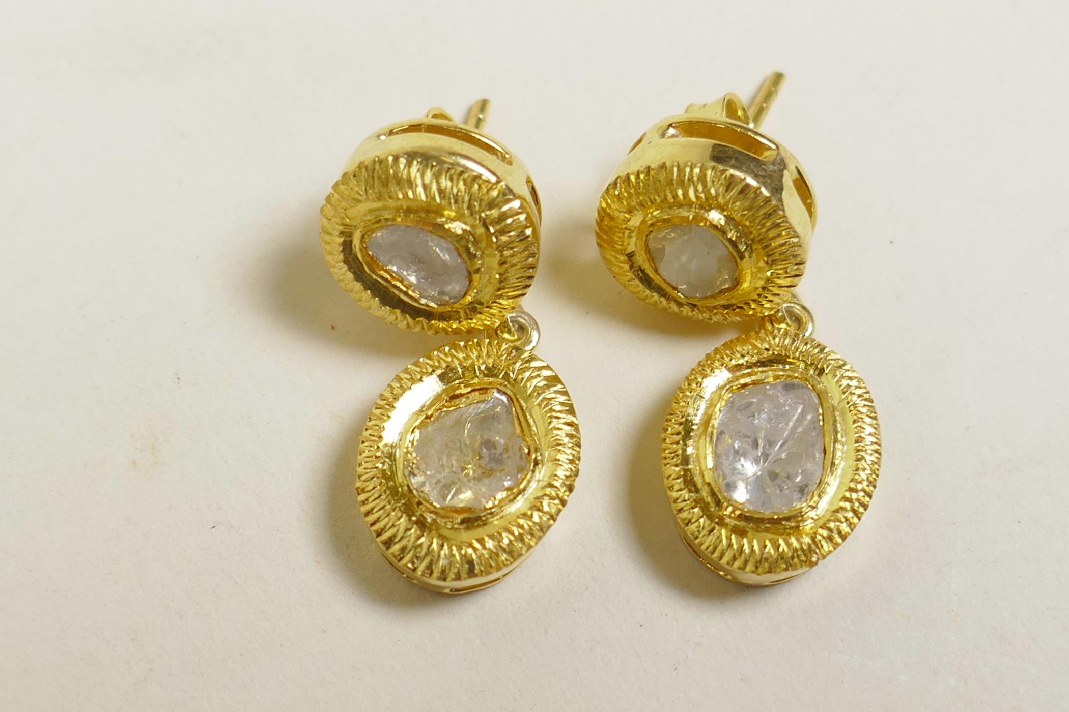 A pair of silver gilt and uncut diamond set drop earrings