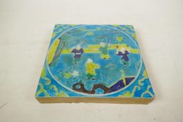 A Chinese fahua glazed porcelain temple tile decorated with children playing in a garden, 8" x 8"