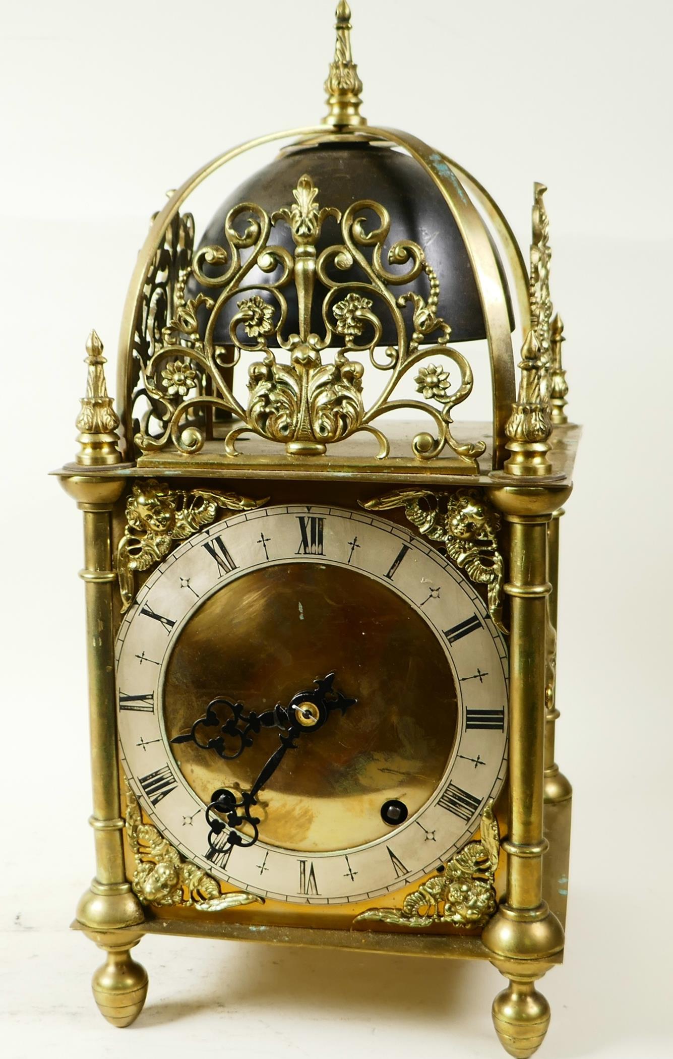 A brass cased lantern clock with two train movement striking on a gong, the case with cast