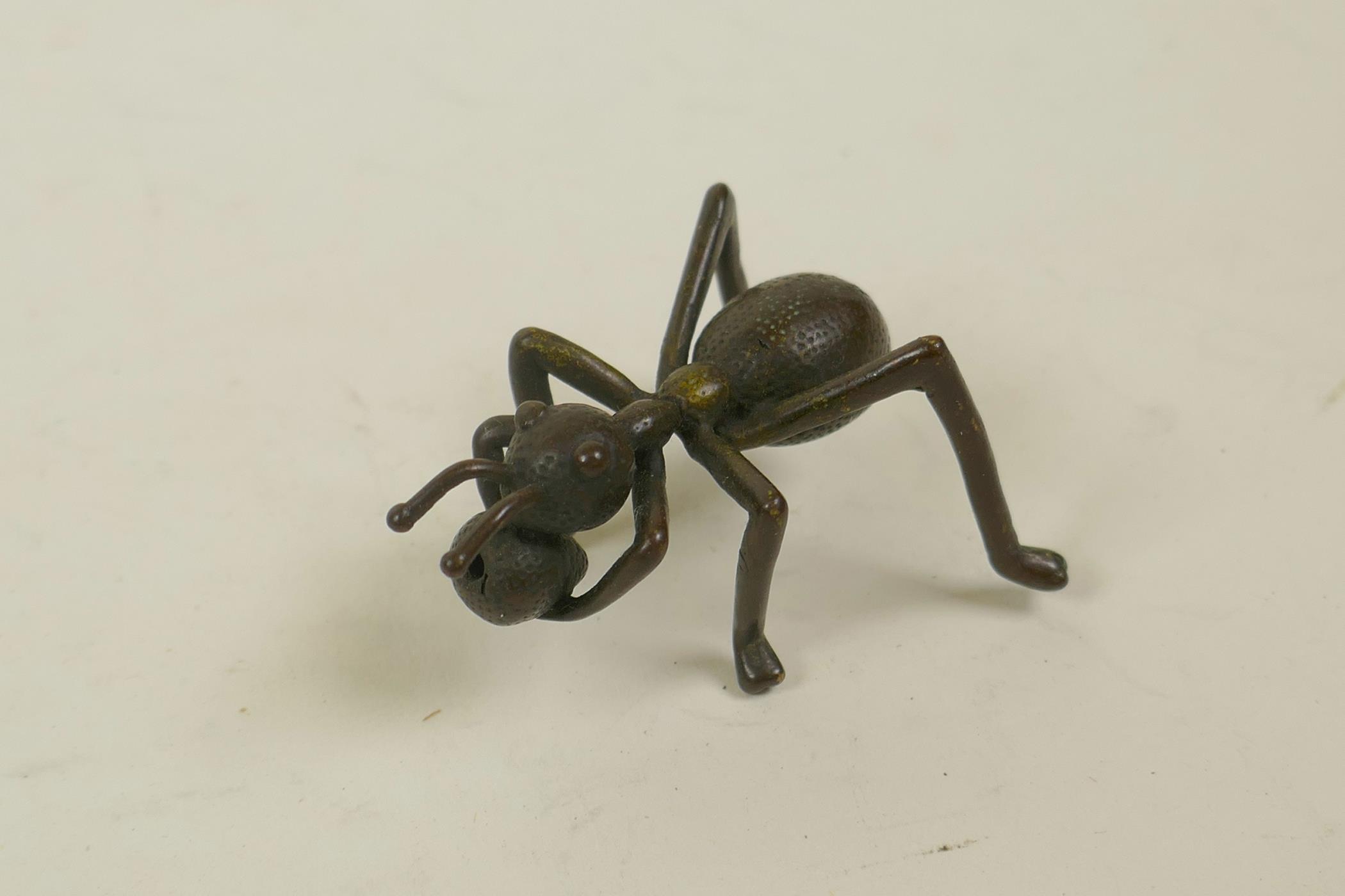 A Japanese Jizai style bronze incense stick holder in the form of an ant, 2" long