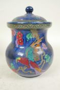 A Losol ware Andes pattern jar and cover decorated with parrot and flowers on a lustre blue