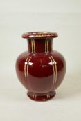 A Chinese flambe glazed pottery vase of ribbed form with a rolled rim, 9½" high