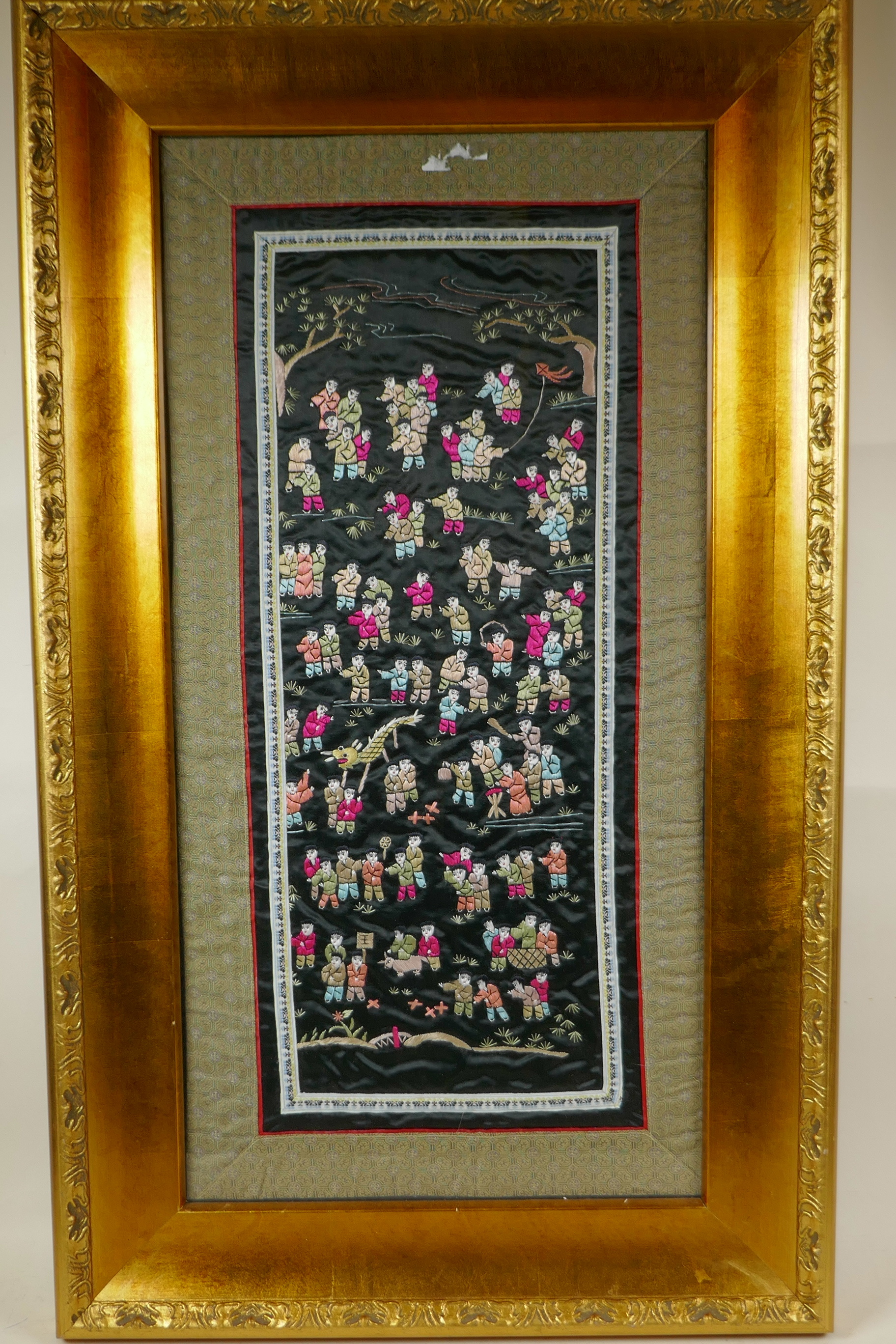 A Chinese silk embroidery depicting the One Hundred Boys, framed, 19" x 32"