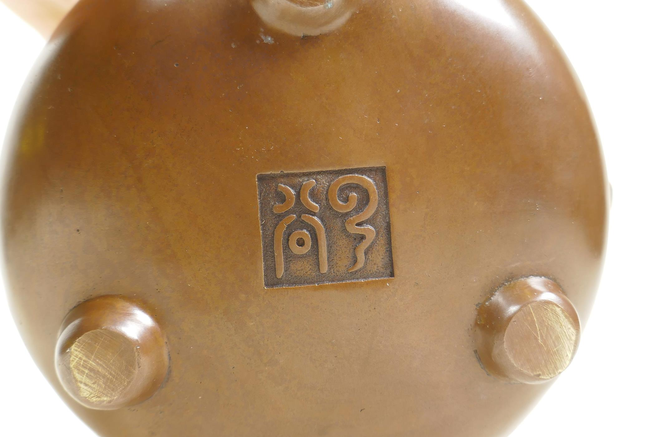 A Chinese bronze censer and cover with two lion mask handles, tripod feet and decorative dragon - Image 4 of 4