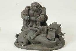 A stylised bronze figure of an ugly man seated on an elephant, 9" long, 7" high