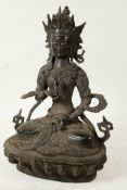 A Chinese bronze figure of Buddha seated in meditation holding a vajra and bell on a lotus throne
