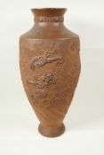 A Japanese red earthenware urn shaped vase with embossed and carved decoration of dragons, 18½" high