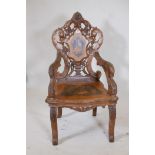 A C19th Swiss inlaid walnut musical open armchair with carved and pierced back and arms, 47½" high