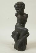 A bronze figure of a stylised boy seated on a rock, 10½" high