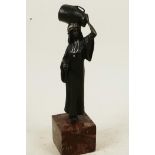 A cold painted bronze figure of an Arab water carrier, mounted on a square hardstone plinth, 7½"
