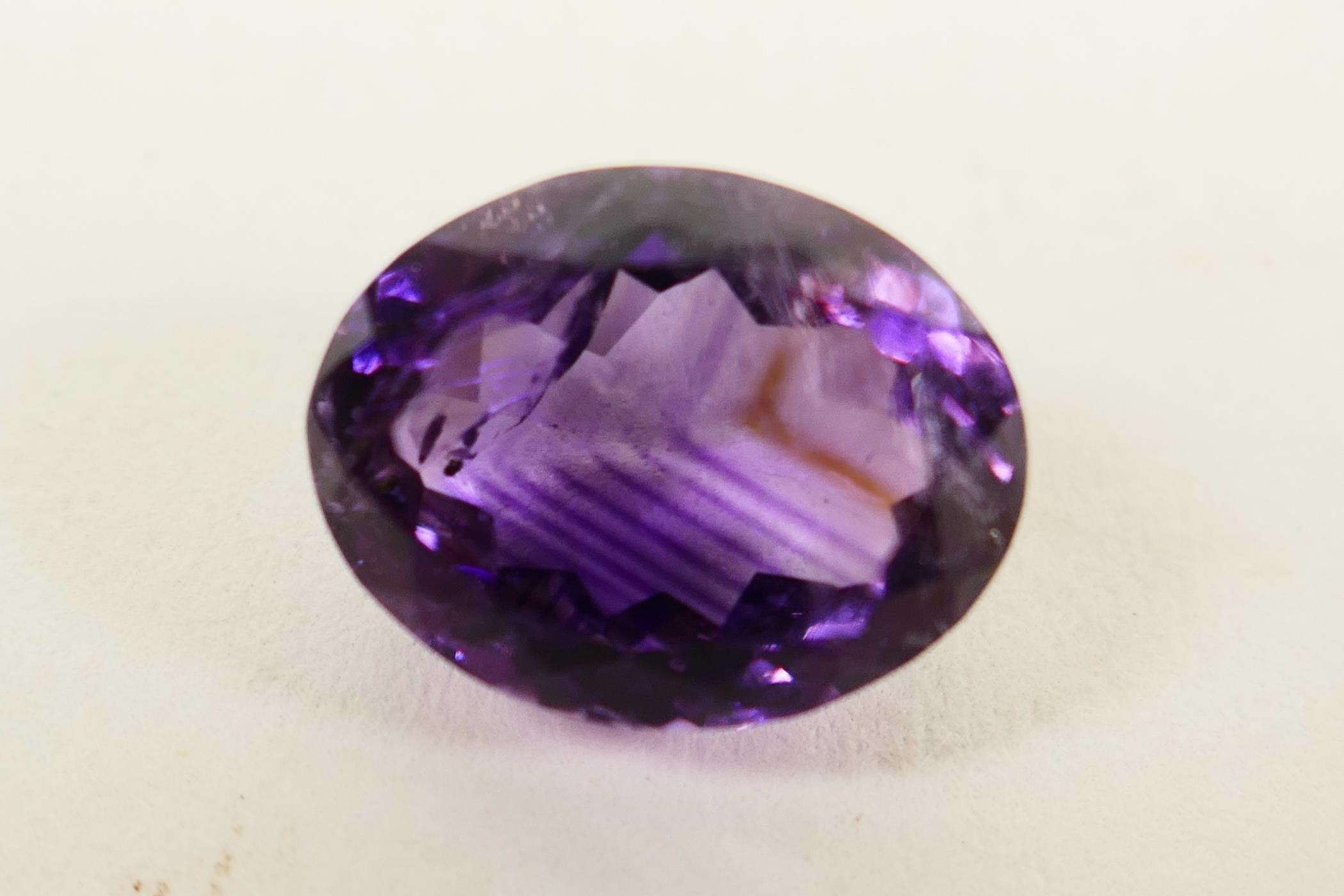 A 6.04ct natural dark purple amethyst, oval mixed cut, certified laboratory tested, with certificate