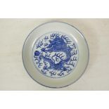 A Chinese blue and white porcelain cabinet dish decorated with a dragon chasing the flaming pearl,