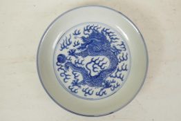 A Chinese blue and white porcelain cabinet dish decorated with a dragon chasing the flaming pearl,