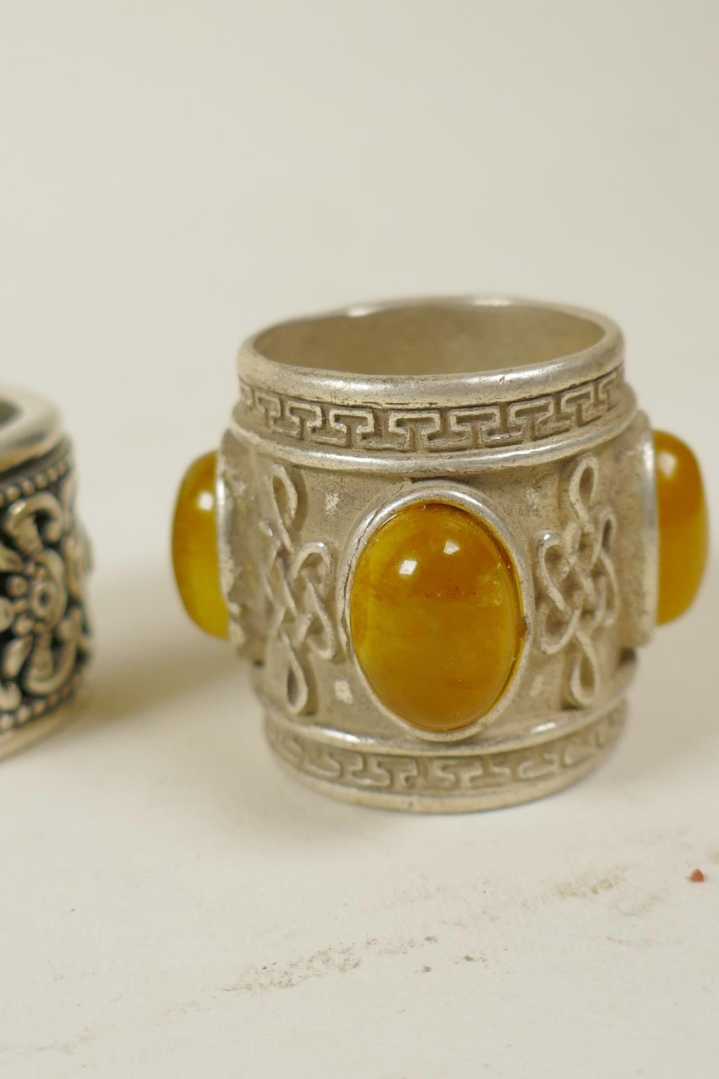 A Chinese white metal archer's thumb ring with a revolving cuff decorated with bats and symbols, and - Image 4 of 4