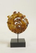 A Chinese hardstone ornament with carved and pierced decoration of a dragon and phoenix, mounted