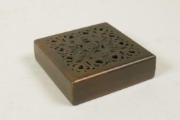 A Chinese bronze square incense box and cover with pierced character decoration to the cover,