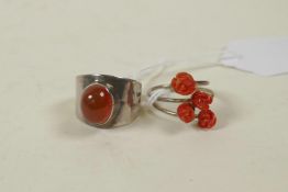 A retro 925 silver and carnelian set ring, and a silver crossover ring set with coral carved in