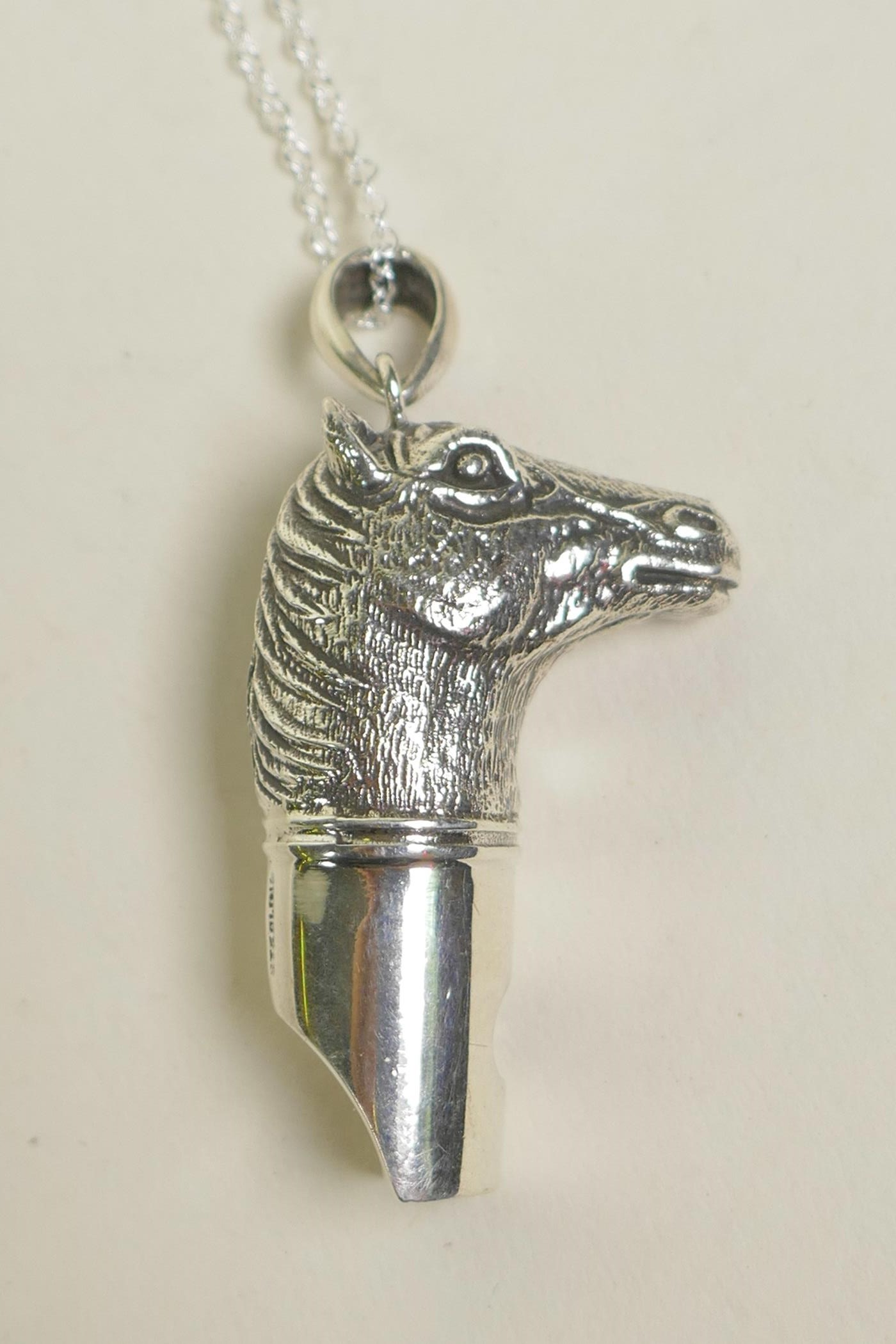 A sterling silver pendant whistle in the form of a horse head, 1½"