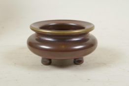 A Chinese copper glazed porcelain censer on tripod feet, with a gilt rim, impressed seal mark to