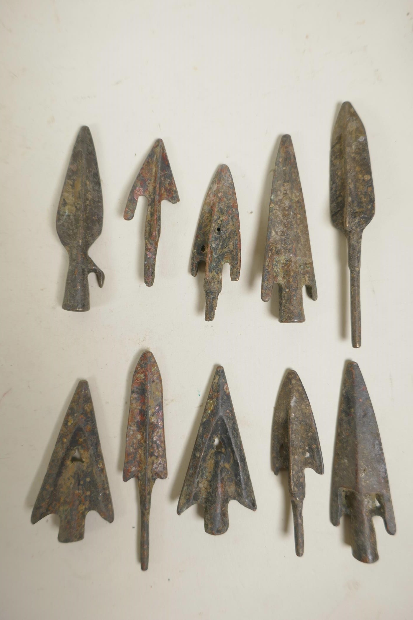 A collection of ten archaic style bronze arrowheads, 3" longest