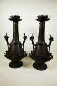 A pair of aesthetic bronze lamp bases in the form of two handled urns with engraved and embossed