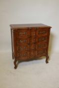 A small French style oak commode, shaped front and four long drawers with carved decoration and