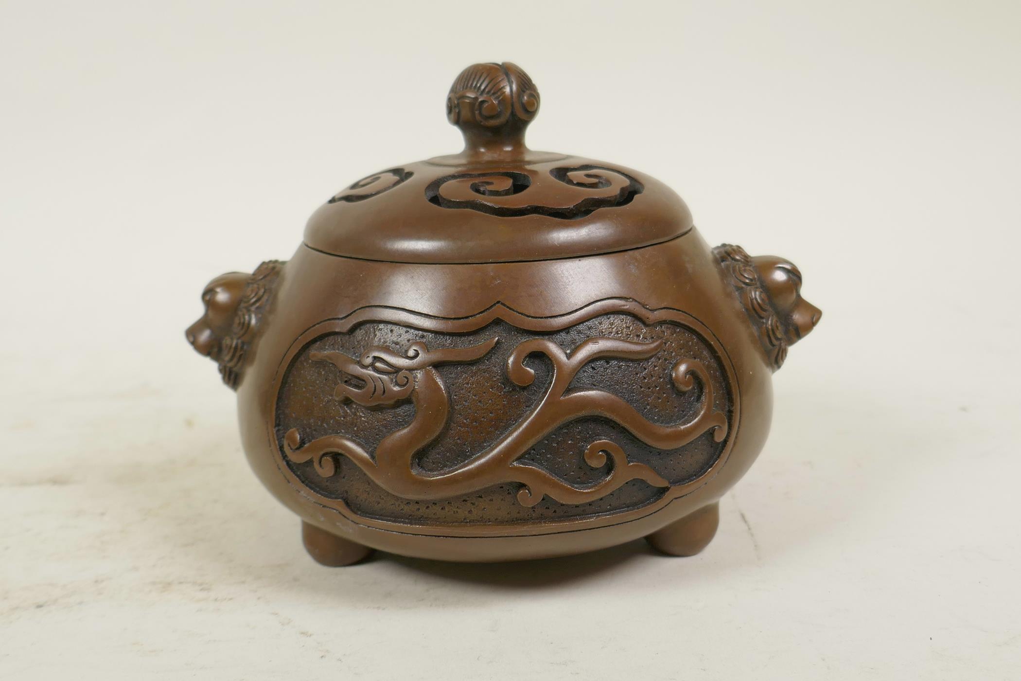 A Chinese bronze censer and cover with two lion mask handles, tripod feet and decorative dragon - Image 3 of 4