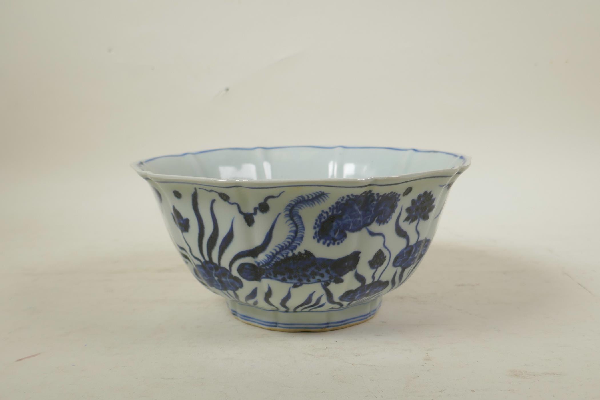 A Chinese Ming style blue and white porcelain bowl of lobed form, decorated with carp in a lotus - Image 4 of 7