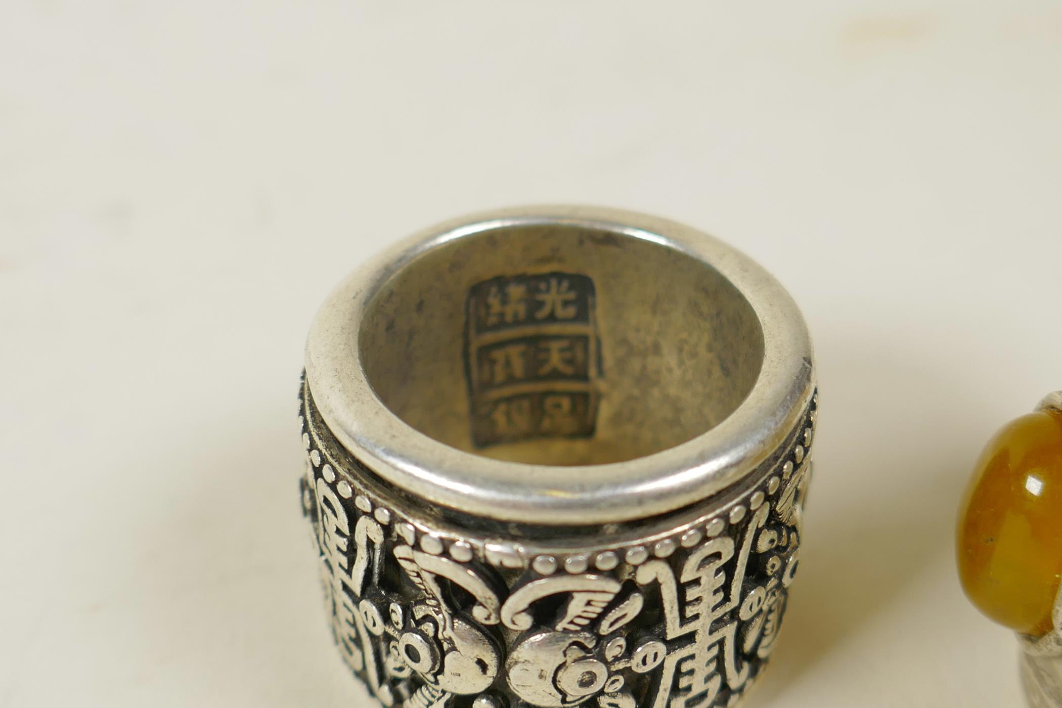 A Chinese white metal archer's thumb ring with a revolving cuff decorated with bats and symbols, and - Image 2 of 4