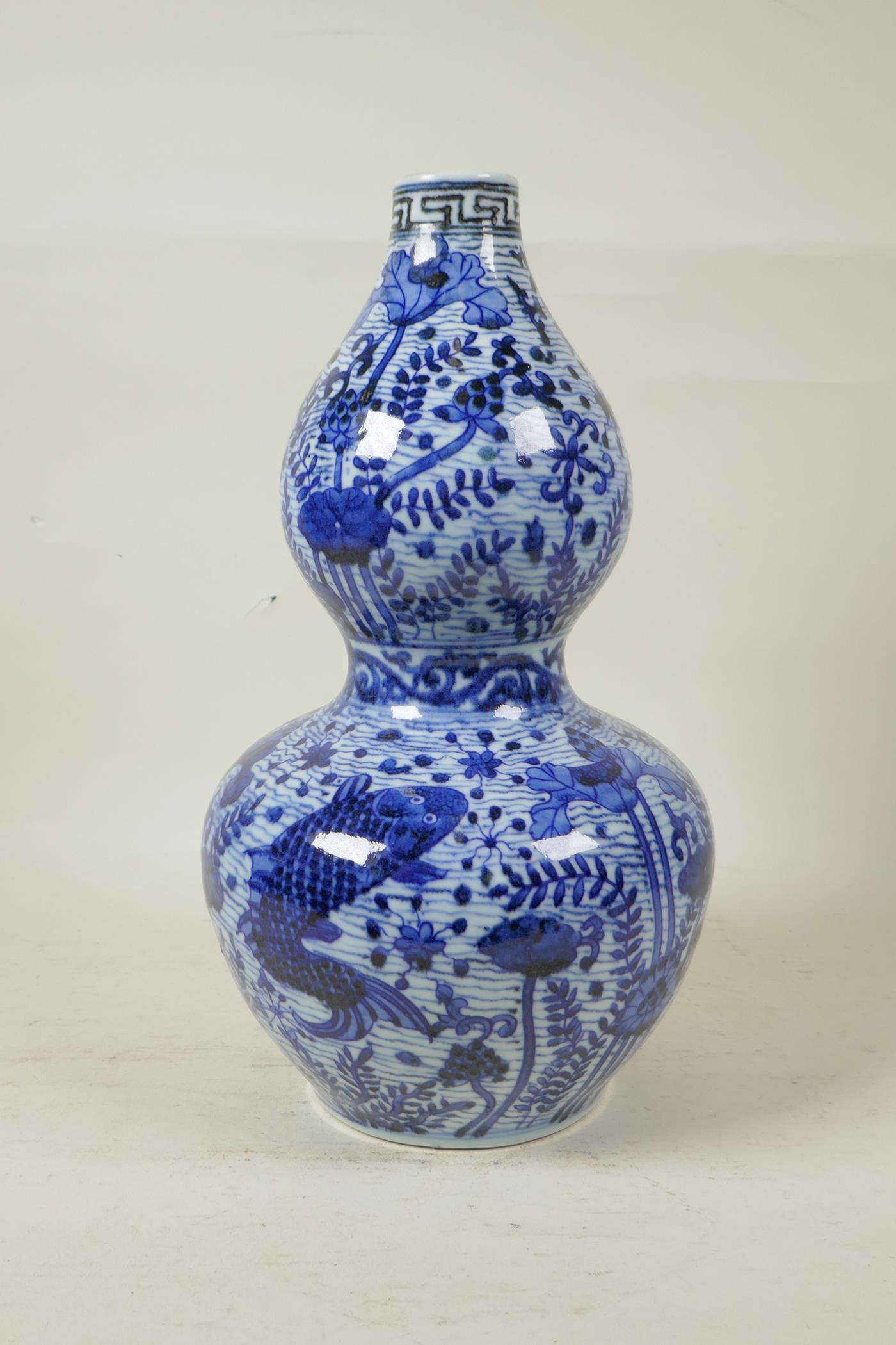 A Chinese Ming style blue and white porcelain double gourd vase decorated with carp in a lotus pond, - Image 3 of 6