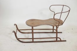 An antique child's sled, wrought iron with a wood seat, 32" x 20"high