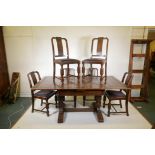 An early C20th oak draw leaf table and six chairs, with a carved frieze and raised on carved bulbous